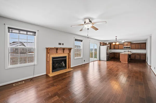 a view of a livingroom with furniture chandelier fireplace and windows