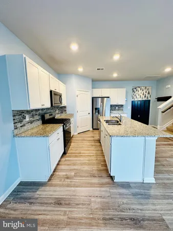 a large kitchen with cabinets and wooden floor
