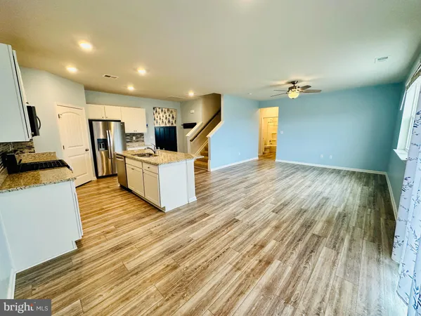 a view of a livingroom with furniture wooden floor and staircase