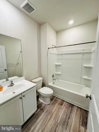 a bathroom with a sink a toilet a mirror and shower