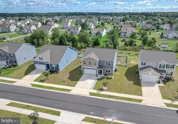 an aerial view of residential houses with outdoor space and parking