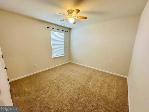 an empty room with a window and a ceiling fan