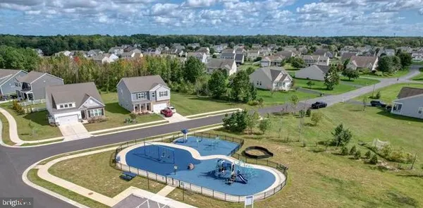 an aerial view of a house with swimming pool and large trees
