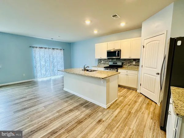 a kitchen with stainless steel appliances granite countertop a stove a sink and a refrigerator