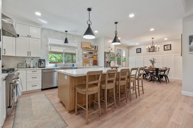 5470 Weatherby Court Reno, NV 89523 - Photo 11 of 33 a kitchen with stainless steel appliances a dining table chairs stove and white cabinets