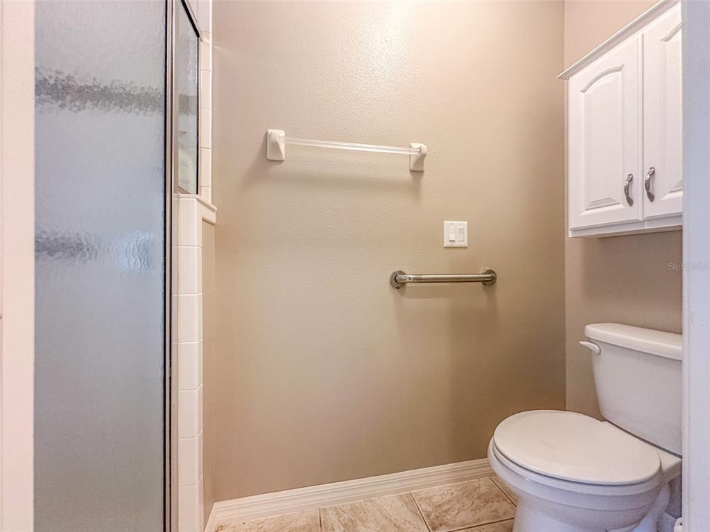 5300 Treasure View Way Leesburg, FL 34748 - Photo 13 of 47 a bathroom with a granite countertop toilet and a shower