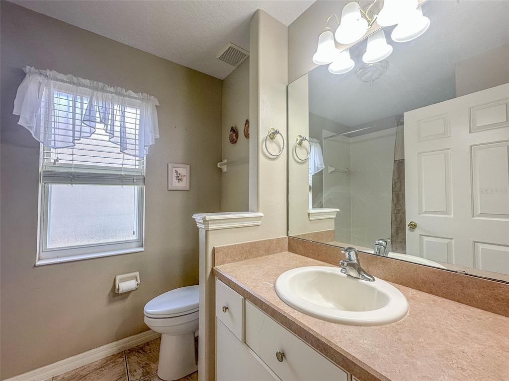 5300 Treasure View Way Leesburg, FL 34748 - Photo 18 of 47 a bathroom with a granite countertop sink toilet and a mirror