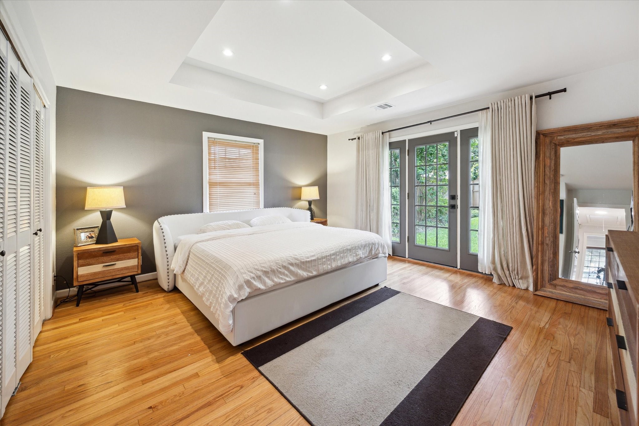 1902 Chimney Rock Road Houston, TX 77057 - Photo 22 of 32 This is the original Primary bedroom with lovely shuttered closets, hardwood floors, floor to ceiling window doors and en-suite primary bath.