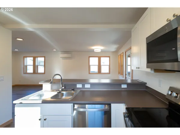a kitchen with a sink cabinets and wooden floor