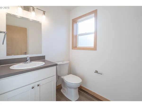 a bathroom with a granite countertop sink a toilet and a mirror