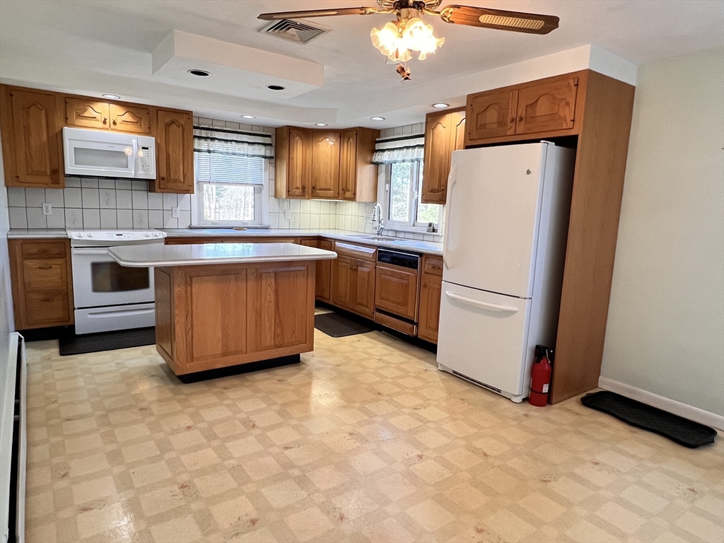 31 Upper Gore Road Webster, MA 01570 - Photo 6 of 33 a kitchen with stainless steel appliances a refrigerator a sink a stove a microwave a dining table and chairs