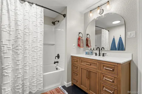 a bathroom with a double vanity sink a mirror a bathtub and shower