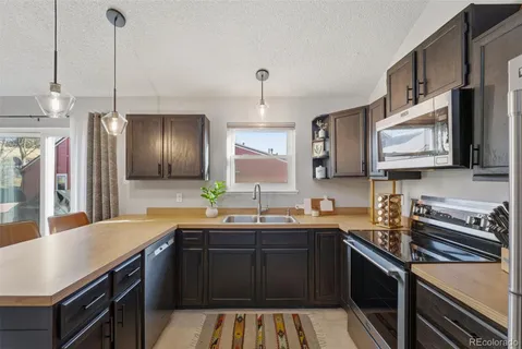a kitchen with stainless steel appliances a sink stove and refrigerator