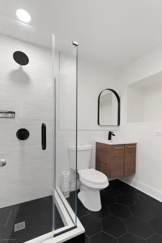 a bathroom with a toilet a sink and mirror