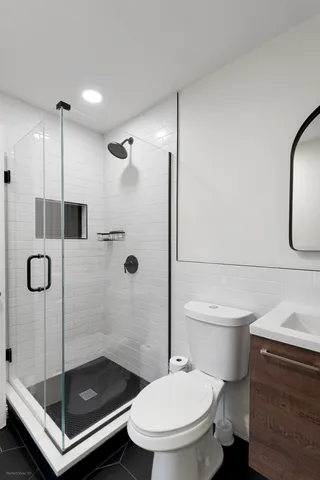 a bathroom with a shower a toilet and sink
