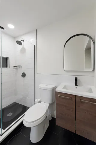 a bathroom with a sink a toilet and shower