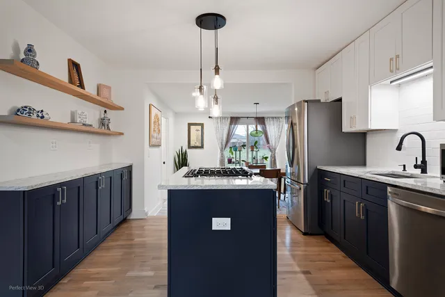 a kitchen with kitchen island a counter top space appliances and a sink