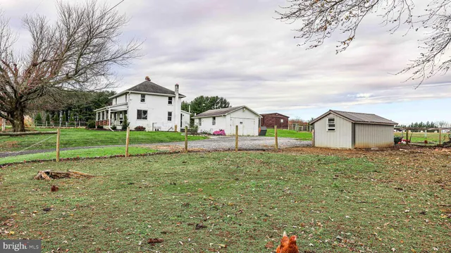 a view of a house with backyard and trees