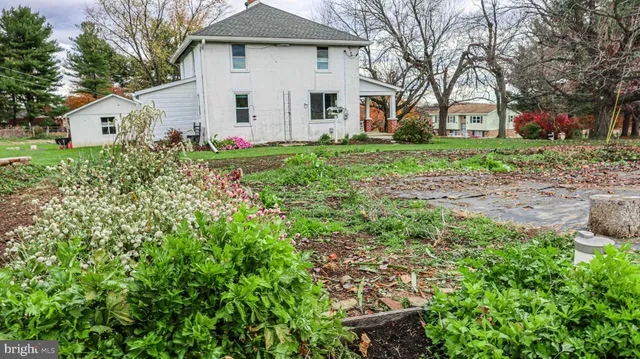 a white house with a yard and large trees