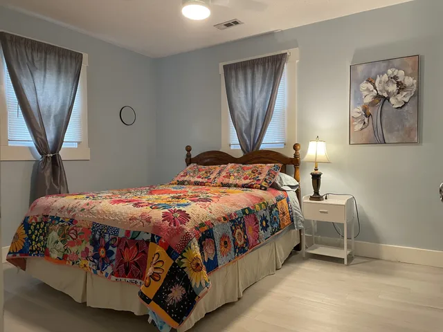 a bedroom with a bed and painting on the wall
