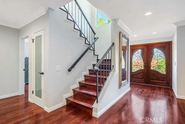 a view of entryway with wooden floor staircase and a window