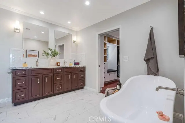 a spacious bathroom with a tub sink and mirror