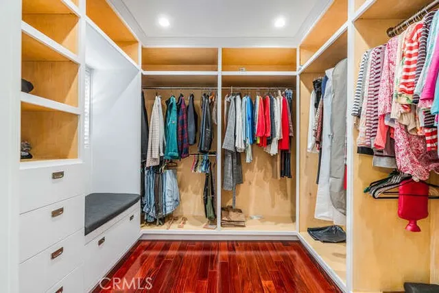 a view of walk in closet with clothes and shoes