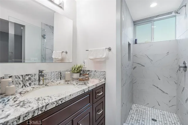 a bathroom with a granite countertop sink and a mirror