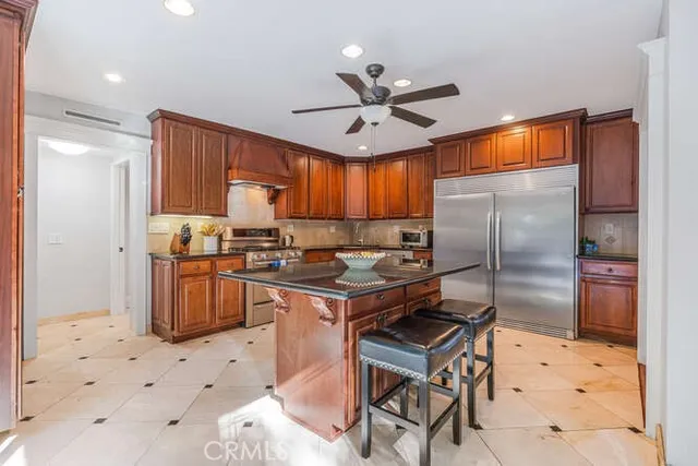 a kitchen with granite countertop a stove refrigerator and cabinets