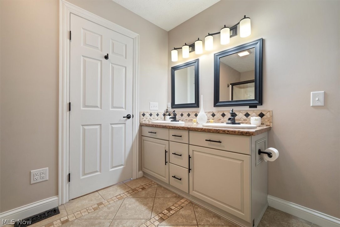 24876 Quarry Road Wellington, OH 44090 - Photo 25 of 50 Bathroom with tile floors, backsplash, and double sink vanity