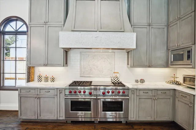 a kitchen with stainless steel appliances granite countertop a stove and a white cabinets