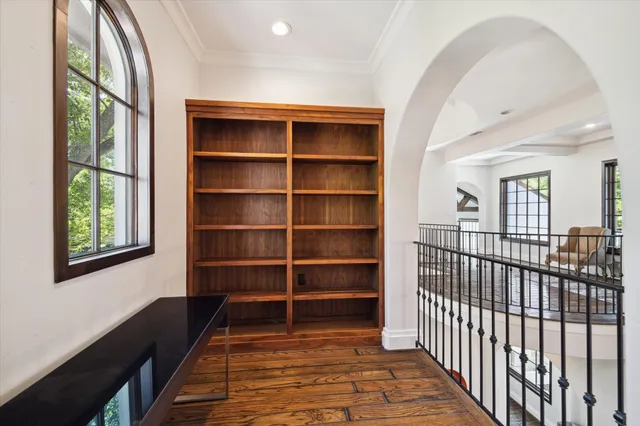 a view of a hallway with wooden floor and a window