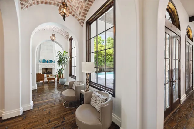 a living room with furniture large window and wooden floor