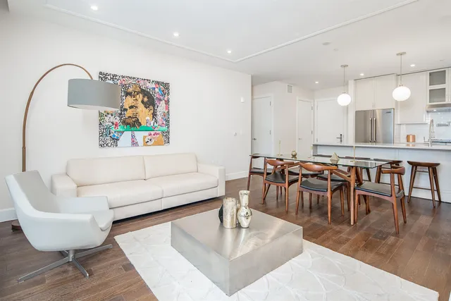 a living room with furniture and a dining table with garden view