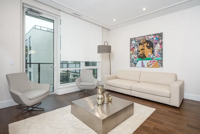 a living room with furniture a rug and a painting on the wall