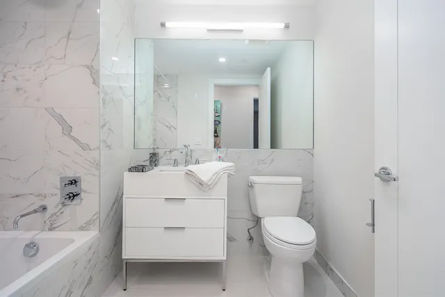 a bathroom with a sink toilet vanity and bathtub