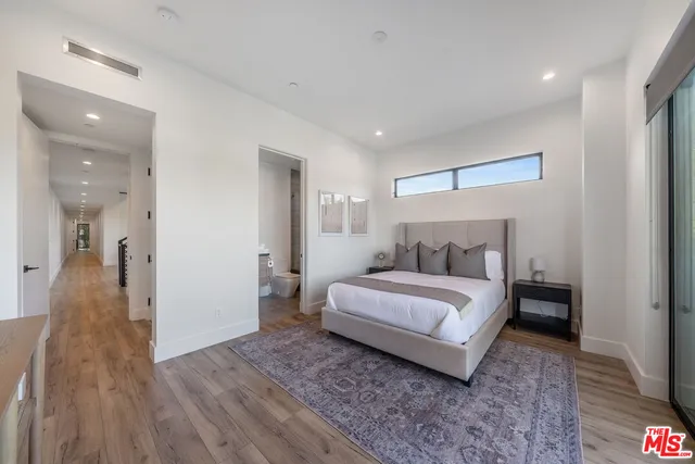 a spacious bedroom with a bed and a lamp