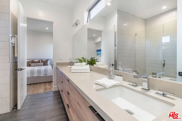 a bathroom with double vanity sinks a vanity two mirror and a shower