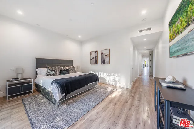 a bedroom with a bed and wooden floor