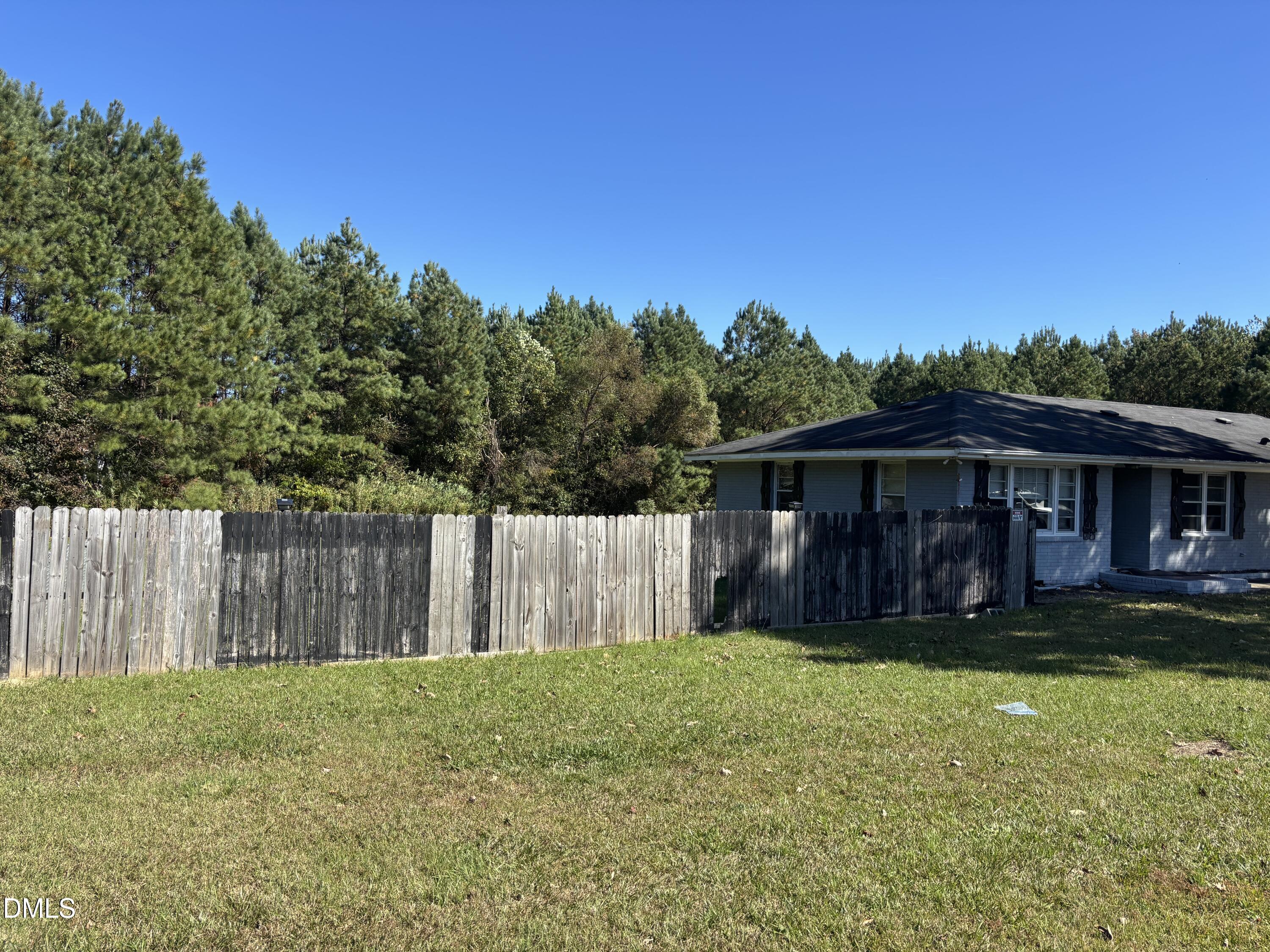 10666 Cleveland Road Garner, NC 27529 - Photo 4 of 8 a view of a yard with a large tree and wooden fence