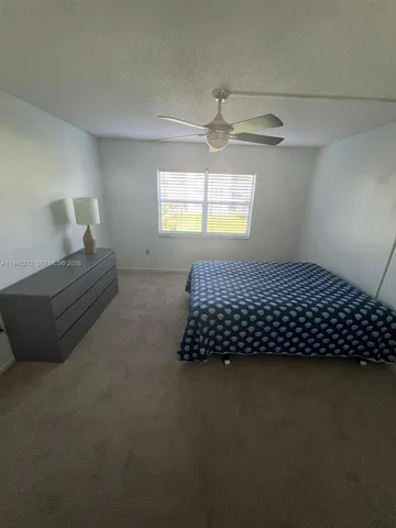 a kitchen with a sink a refrigerator and white cabinets