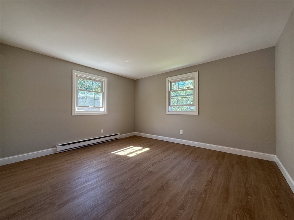 96 Richardson Road, Unit A22 Chelmsford, MA 01863 - Photo 11 of 22 a view of an empty room with wooden floor and a window