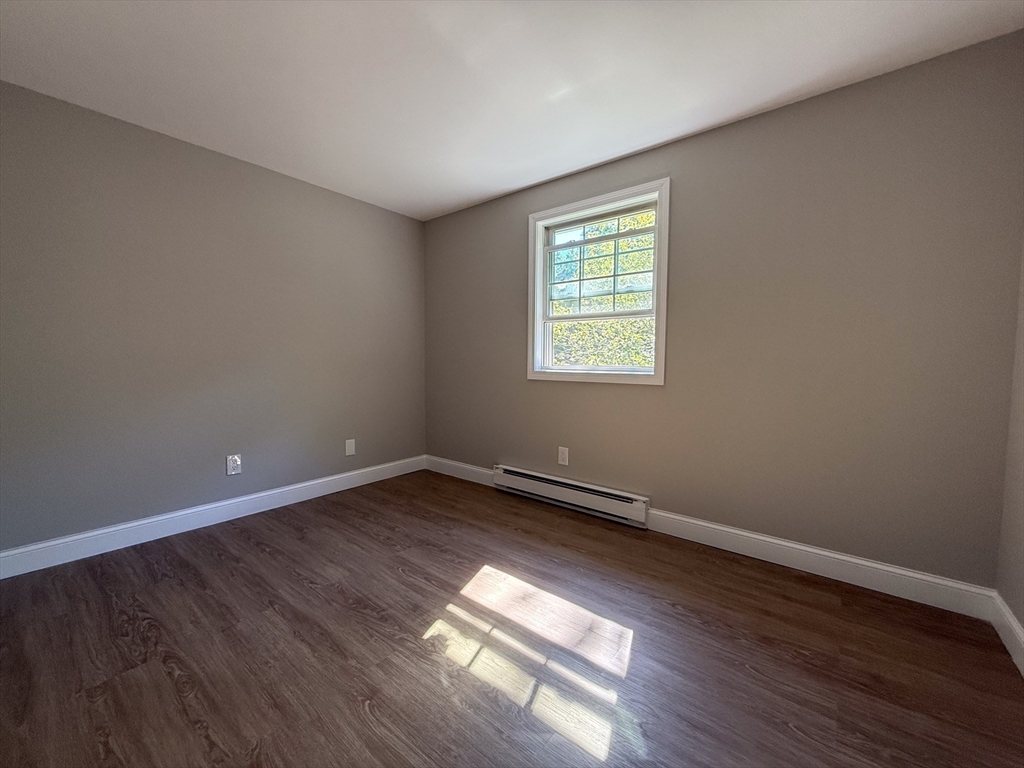 96 Richardson Road, Unit A22 Chelmsford, MA 01863 - Photo 14 of 22 a view of an empty room with wooden floor and a window