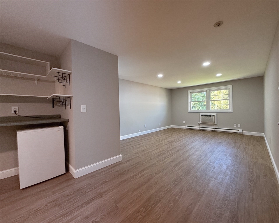 96 Richardson Road, Unit A22 Chelmsford, MA 01863 - Photo 2 of 22 a view of an empty room with wooden floor and a window