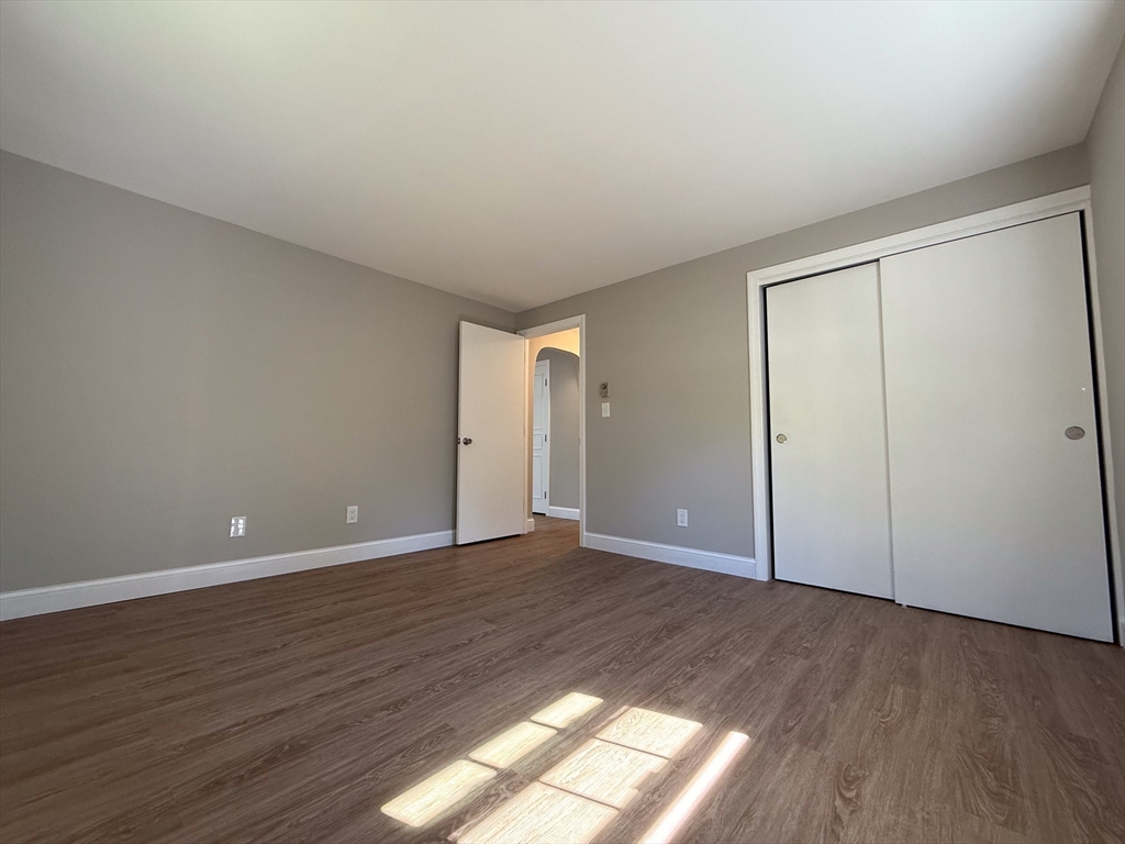 96 Richardson Road, Unit A22 Chelmsford, MA 01863 - Photo 9 of 22 a view of an empty room with wooden floor and a window
