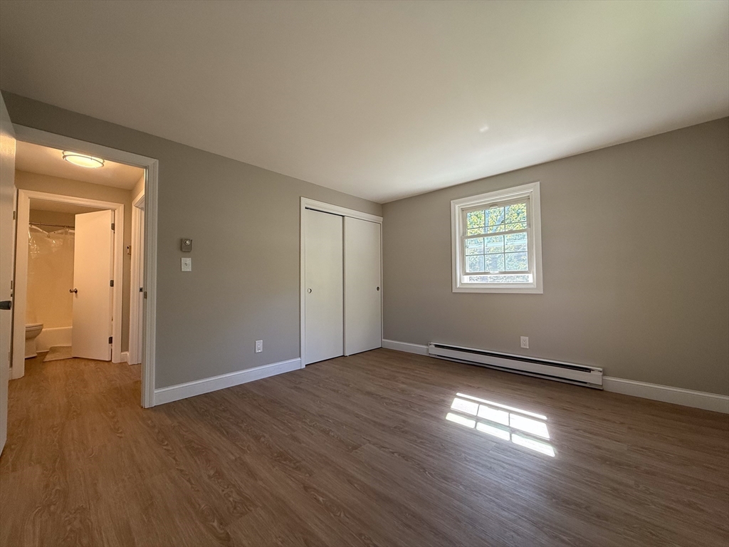 96 Richardson Road, Unit A22 Chelmsford, MA 01863 - Photo 10 of 22 an empty room with wooden floor and windows