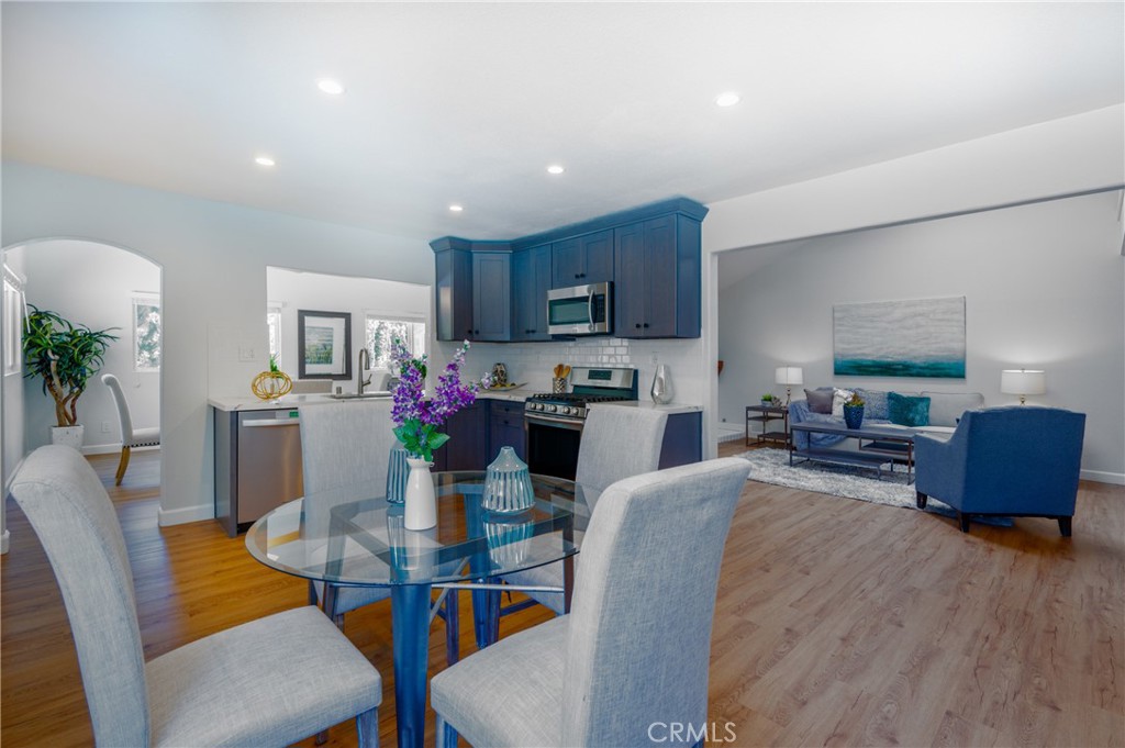 4829 East Kenyon Place Orange, CA 92869 - Photo 11 of 42 a kitchen with stainless steel appliances granite countertop a dining table chairs and a living room