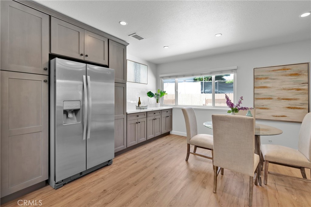 4829 East Kenyon Place Orange, CA 92869 - Photo 13 of 42 a kitchen with refrigerator cabinets and dining table