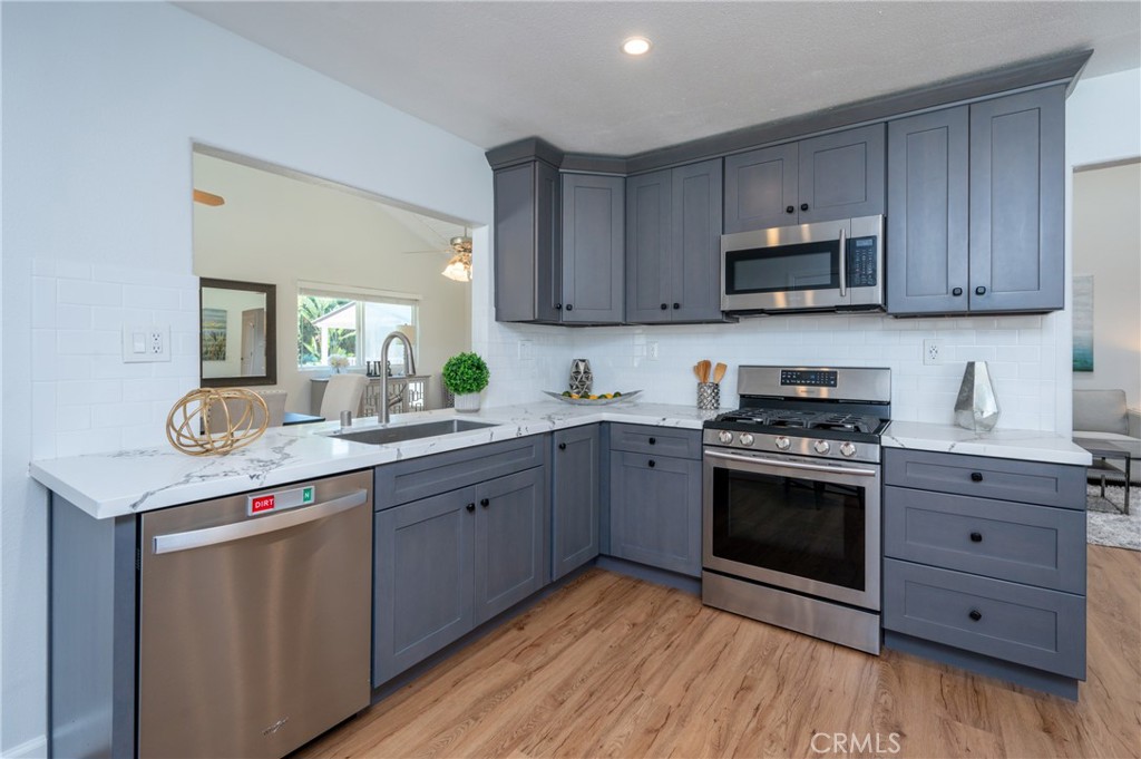 4829 East Kenyon Place Orange, CA 92869 - Photo 5 of 42 a kitchen with stainless steel appliances granite countertop a stove a sink and a microwave