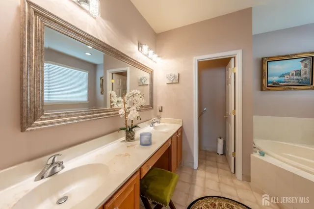 a en suite bathroom with a granite countertop sink a toilet a mirror and shower